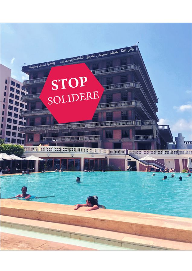 The derelict St. George Hotel behind a Stop Solidere banner, with the swimming pool in use below